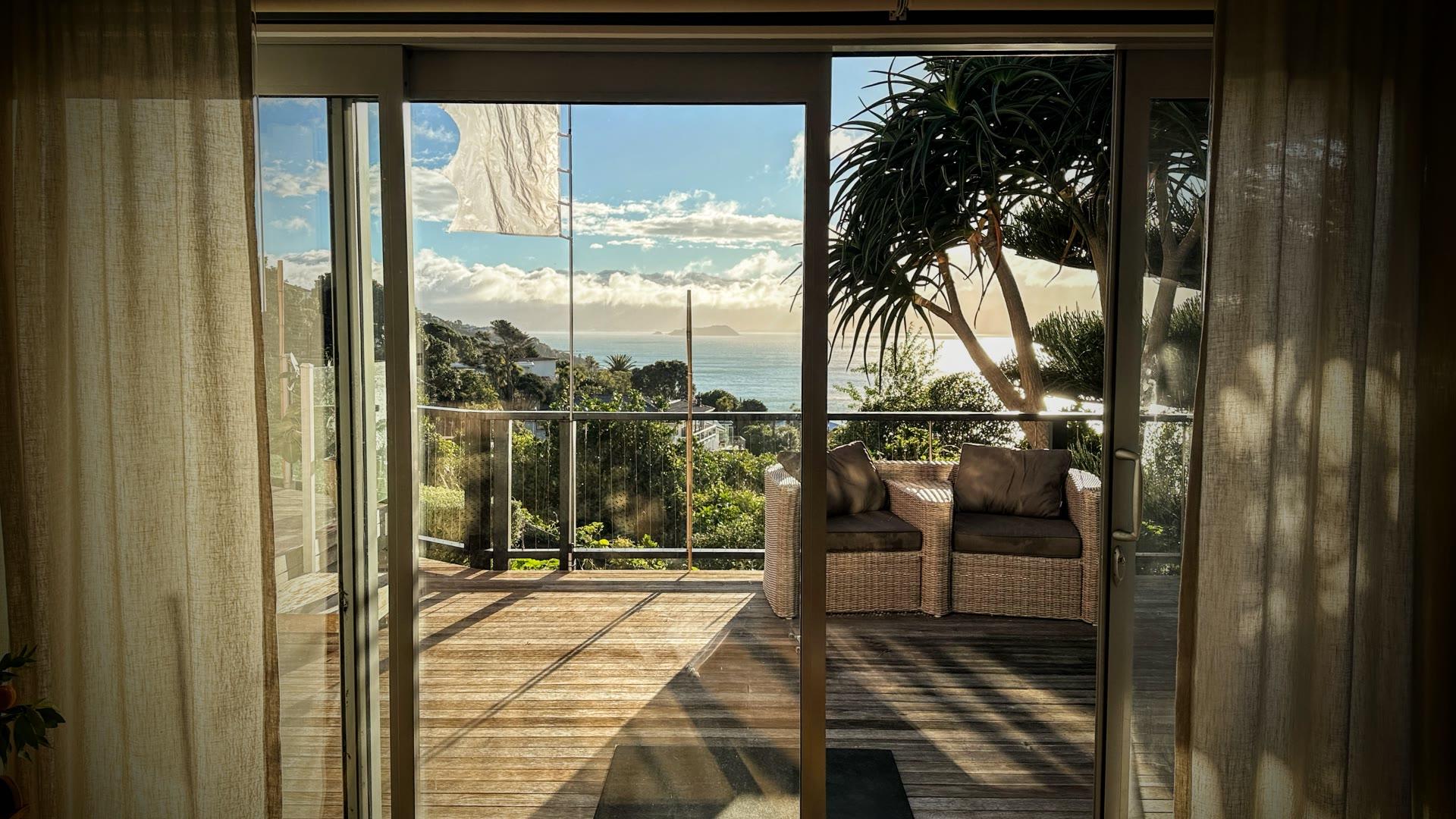 Studio Mergence: light-filled room opening onto a deck with a Seatoun harbour view